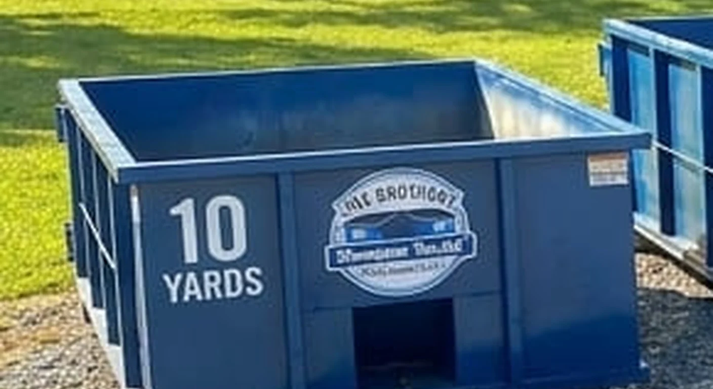 A clean, correctly-labeled 10 yard HNV Brothers Dumpster Rental roll-off container staged at the company yard